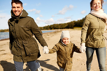 Image showing happy family walking along autumn beach