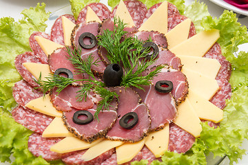 Image showing Sliced on a plate of sausage and cheese, decorated with greens and olives