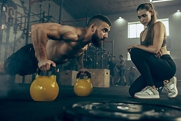 Image showing Fit young man lifting barbells working out in a gym