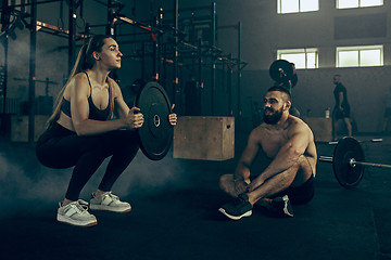 Image showing Fit young woman lifting barbells working out in a gym