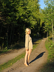 Image showing Girl wolking away along the forest roud