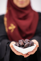 Image showing modern muslim woman holding a plate of dates in ramadan kareem