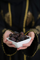 Image showing modern muslim woman holding a plate of dates in ramadan kareem