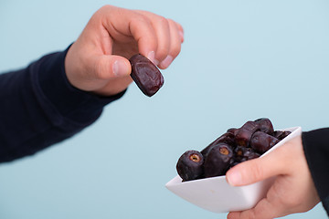 Image showing modern muslim woman holding a plate of dates in ramadan kareem