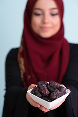 Image showing modern muslim woman holding a plate of dates in ramadan kareem