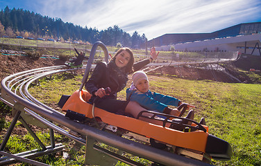 Image showing young mother and son driving alpine coaster