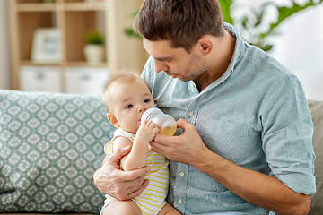 Image showing father and baby drinking from bottle at home