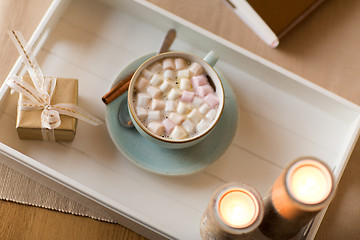 Image showing hot chocolate, christmas gift and candles on table