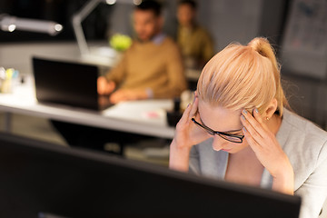 Image showing stressed businesswoman working at night office