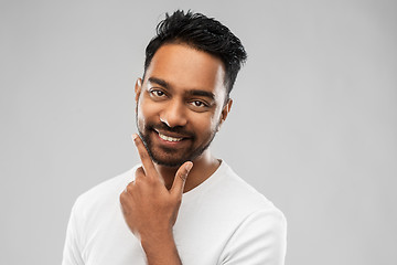 Image showing smiling indian man touching his beard