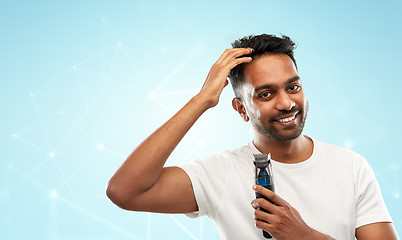 Image showing smiling indian man with trimmer touching his hair