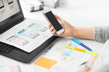 Image showing web designer with smartphone and laptop at office