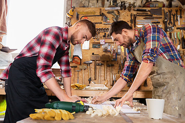 Image showing carpenters with ruler and blueprint at workshop