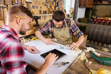 Image showing carpenters with tablet and blueprint at workshop