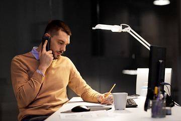 Image showing businessman calling on sartphone at night office