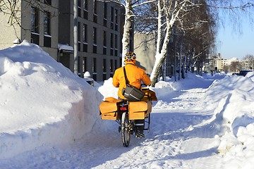 Image showing the postman rides a bicycle among the snowdrifts