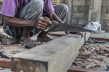 Image showing Close up of warn hands of carpenter working in traditional manual carpentry shop in a third world country.