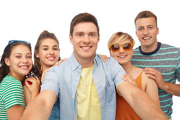 Image showing happy friends taking selfie over white background