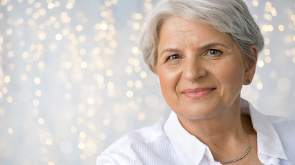 Image showing portrait of senior woman over festive lights