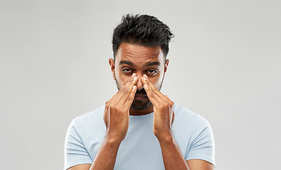 Image showing indian man rubbing nose