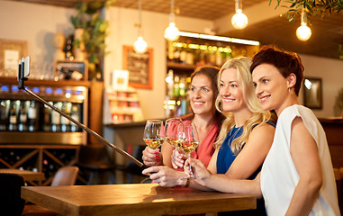 Image showing women taking picture by selfie stick at wine bar