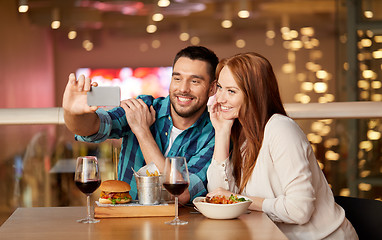 Image showing couple taking selfie by smartphone at restaurant