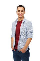 Image showing smiling young man holding hands in pockets