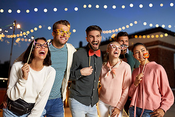 Image showing happy friends with party props at rooftop