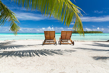 Image showing tropical beach with palm tree and sunbeds