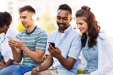 Image showing friends with smartphones hanging out in summer