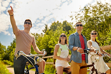Image showing happy friends riding fixed gear bicycles in summer