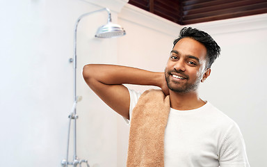 Image showing smiling indian man with bath towel over shower