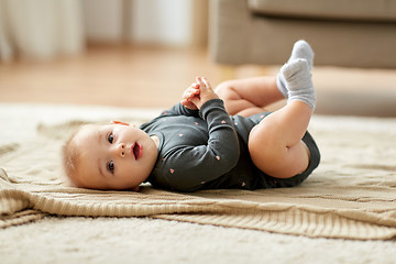 Image showing lovely baby girl lying on floor at home