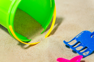 Image showing close up of bucket and rake on beach sand