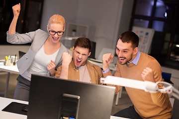 Image showing business team celebrating success at night office