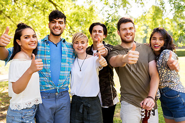 Image showing friends with guitar showing thumbs up at park