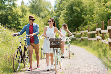 Image showing happy friends with fixed gear bicycles in summer