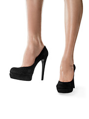 Image showing Tanned female legs in high heels isolated on white background.