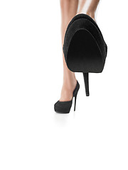 Image showing Tanned female legs in high heels isolated on white background.