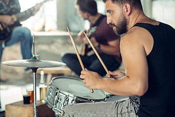 Image showing Repetition of rock music band. Electric guitar player and drummer behind the drum set.