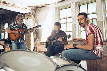 Image showing Repetition of rock music band. Electric guitar player and drummer behind the drum set.