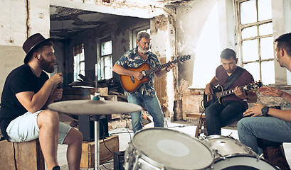 Image showing Repetition of rock music band. Electric guitar player and drummer behind the drum set.