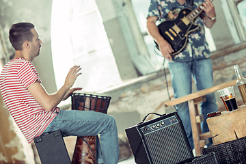 Image showing Repetition of rock music band. Electric guitar player and drummer behind the drum set.