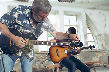 Image showing Repetition of rock music band. Electric guitar player and drummer behind the drum set.