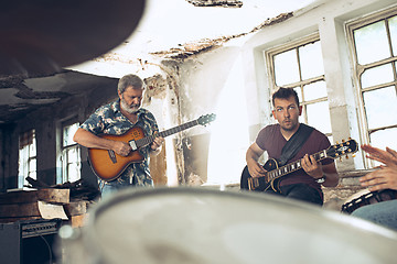 Image showing Repetition of rock music band. Electric guitar player and drummer behind the drum set.