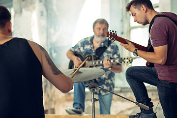 Image showing Repetition of rock music band. Electric guitar player and drummer behind the drum set.