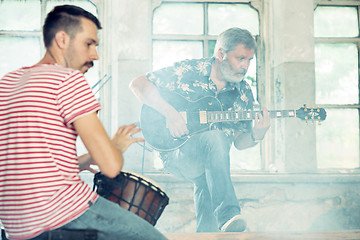 Image showing Repetition of rock music band. Electric guitar player and drummer behind the drum set.