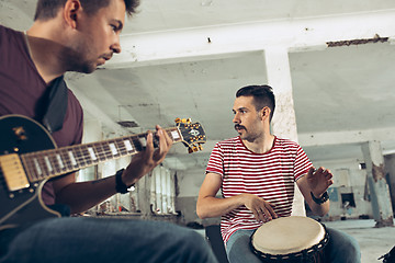 Image showing Repetition of rock music band. Electric guitar player and drummer behind the drum set.