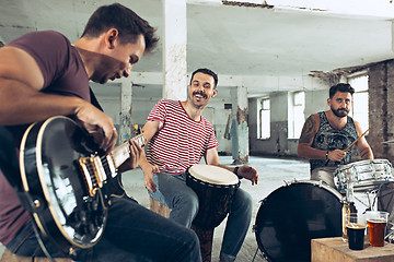 Image showing Repetition of rock music band. Electric guitar player and drummer behind the drum set.