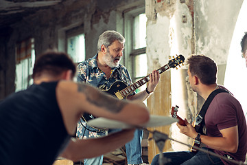 Image showing Repetition of rock music band. Electric guitar player and drummer behind the drum set.